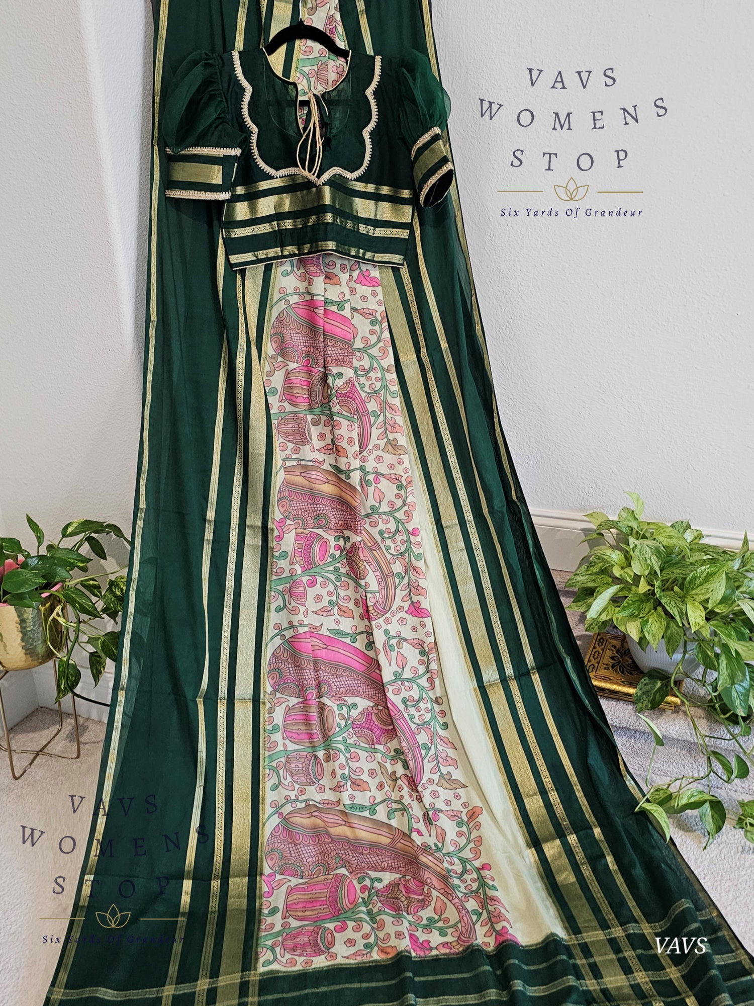 Green saree with floral patterns on a white background, featuring 'VAVS Women's Stop' branding.